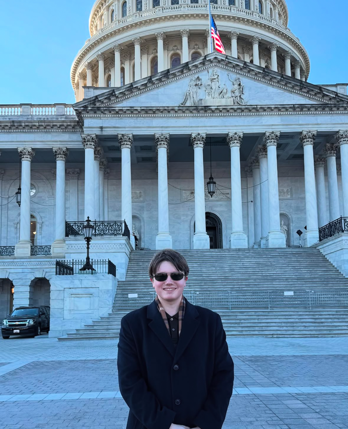 Lane at the US Capitol building wearing sunglasses