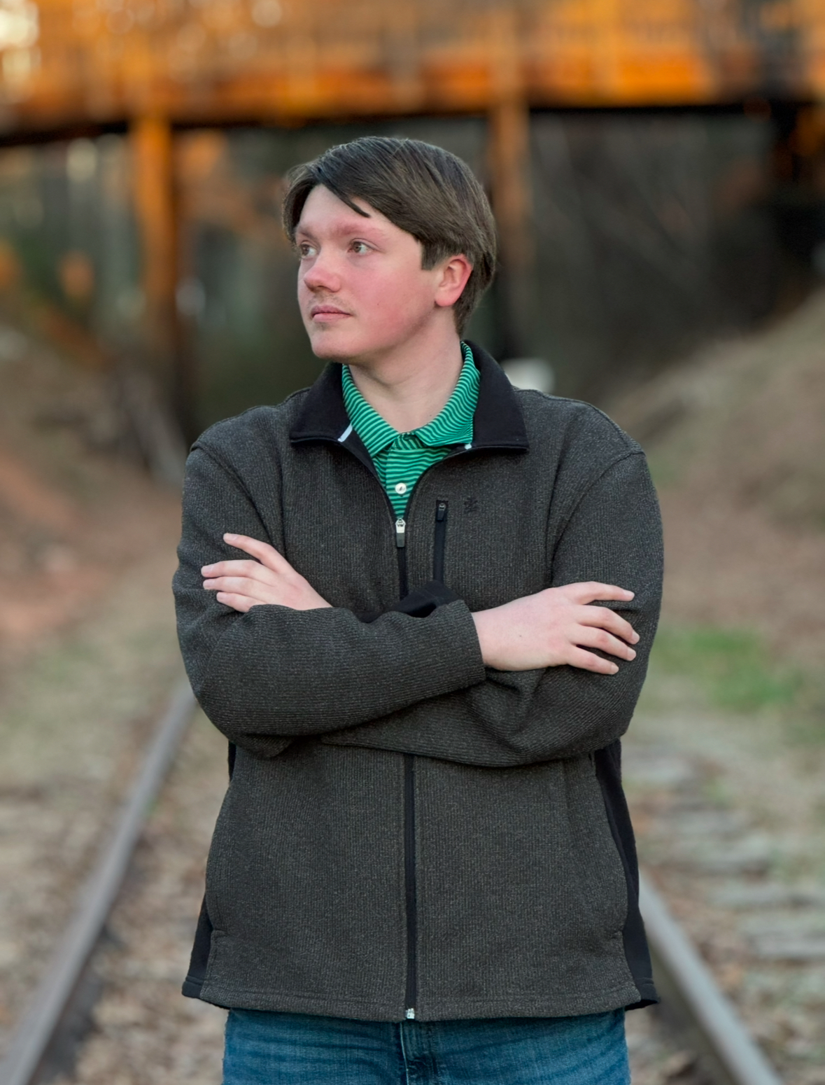 Lane on railroad tracks in green jacket